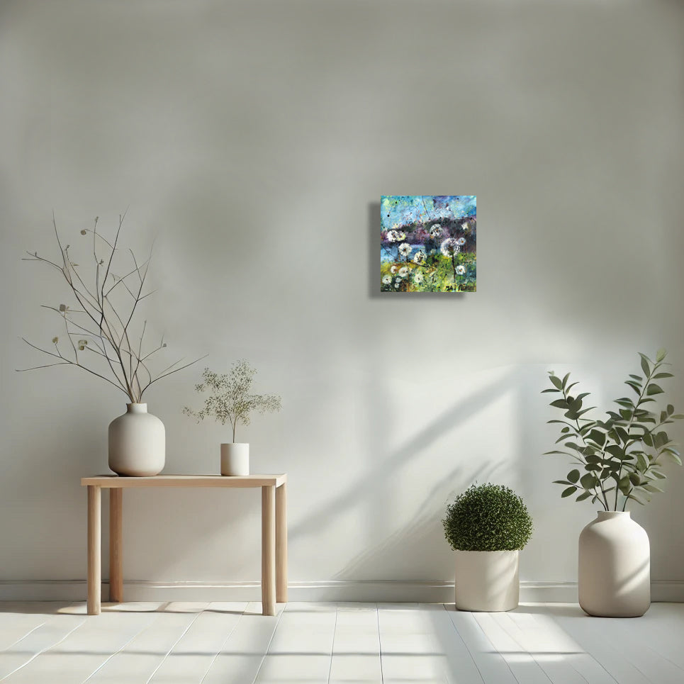 Whispers of the Dandelions by Nimchi Yuen displayed in a cozy room, featuring whimsical dandelions against a sky and mountain backdrop, adding charm to the decor.