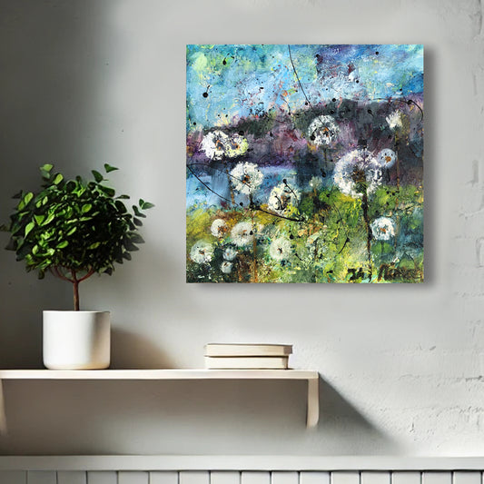 Whispers of the Dandelions by Nimchi Yuen displayed in a cozy room, featuring whimsical dandelions against a sky and mountain backdrop, adding charm to the decor.